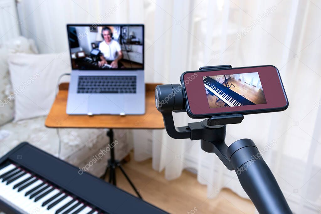 A smartphone placed on a gimbal used as second camera for online piano lessons.