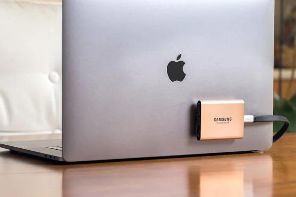 Een Samsung T5 draagbare SSD harde schijf aangesloten op een Macbook Pro laptop. — Stockfoto