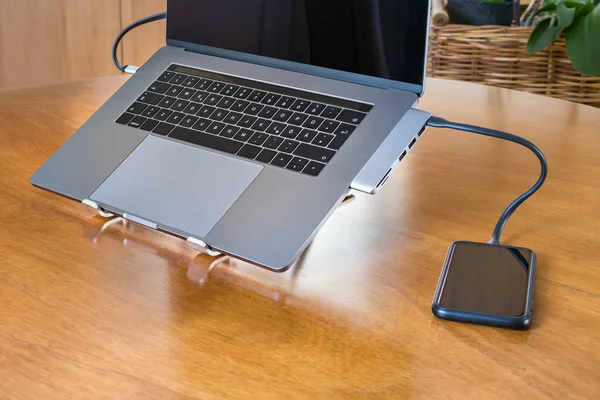 Smartphone wordt opgeladen met een hub adapter op een laptop — Stockfoto