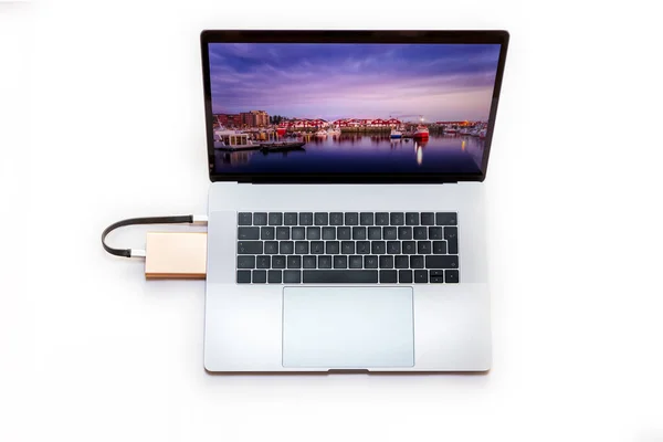Vista superior de um laptop conectado a um disco rígido externo SSD portátil de 2,5 polegadas via cabo USB tipo C isolado sobre fundo branco — Fotografia de Stock