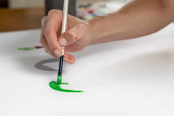 Nahaufnahme eines Künstlers Handmalerei auf Papier mit Acryl in der Hand eines Pinsels — Stockfoto