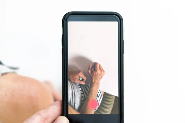 Hand met een smartphone die foto 's maakt van een handtekening op een papier — Stockfoto