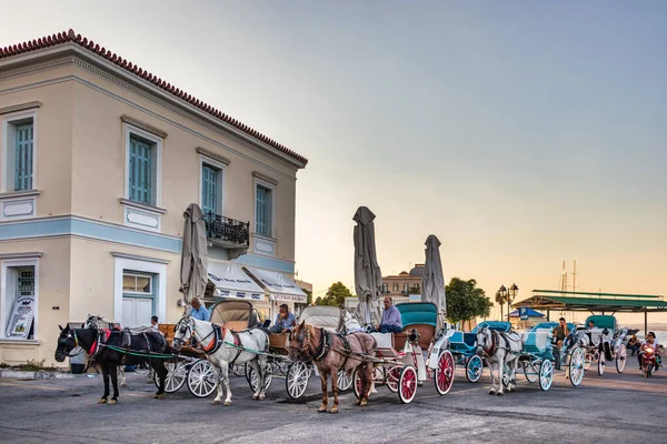 Akşamları Dapia limanındaki ana durak istasyonunda at arabaları, Spetses, Yunanistan.