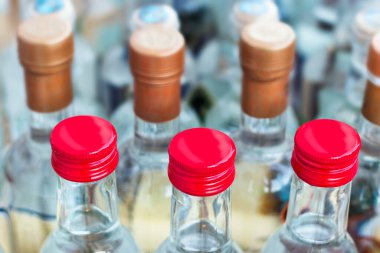 Arka arkaya yerleştirilen küçük şeffaf şişelere kırmızı vida tıklamalarını kapat.