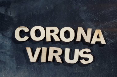 Corona Virüsü, metal bir yüzeyde tahta harflerle yazılıyor.