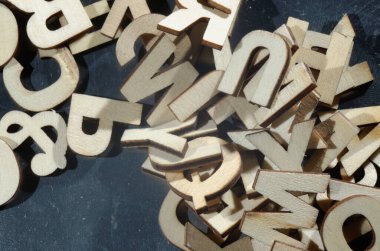 Metal bir yüzeyde karışık ahşap harfler yığını