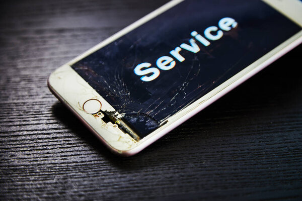 Изображение смартфона со сломанным экраном и словом Service на нем
