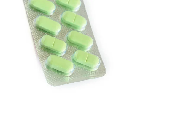 Beyaz arka plan üzerinde izole blister paketi yeşil tıbbi haplar — Stok fotoğraf