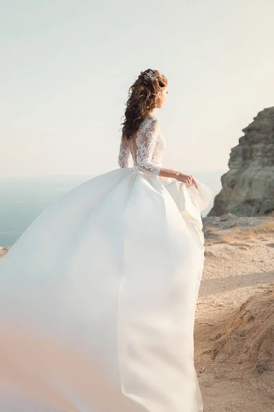 Gün batımı üzerinde dağların güzel manzara üzerinde ayakta şık gelin