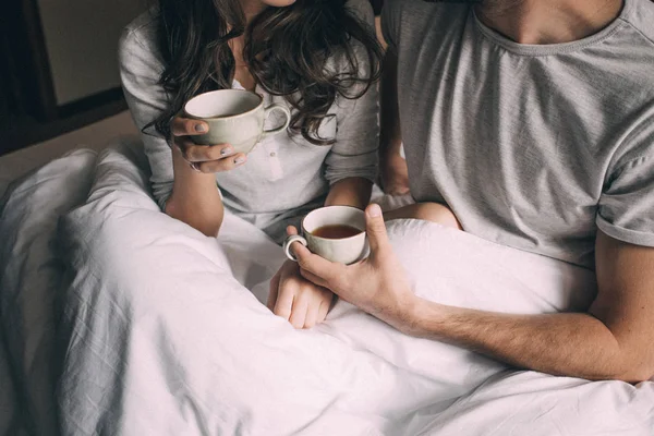 Amantes segurando juntos uma xícara de chá — Fotografia de Stock