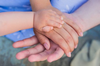 Birlik, destek, koruma, mutluluk kavramı. Çocuk el iyle anne babaya yakın. Baba, anne, el ele küçük bebek tut. Bebek elinin ebeveynlerin eline yakınlığı