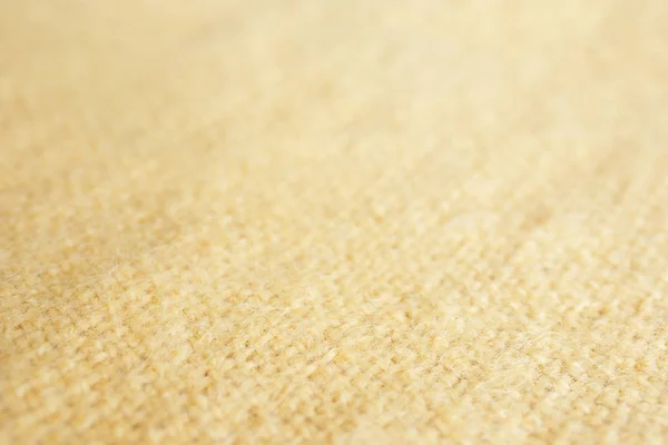 Background blur picture of a soft fur yellow carpet. wool sheep fleece closeup texture background. Fake color yellow fur fabric. top view