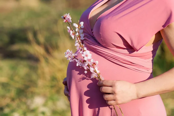 Ciąża szczęśliwa dziewczyna w ogrodzie brzoskwinia kwiat — Zdjęcie stockowe