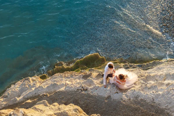 Sahilde oturan genç çift birbirlerine bakıyor