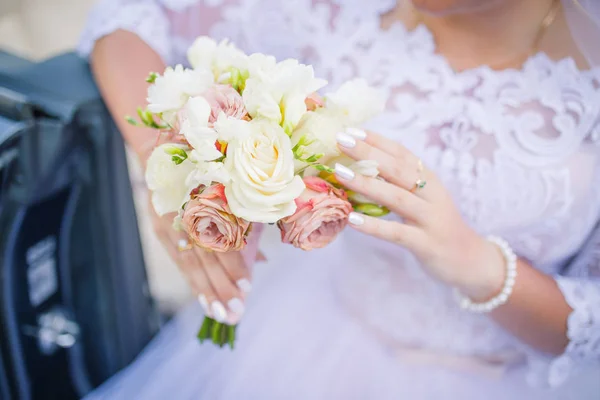 ぼやけた背景の結婚式のテーマ。花嫁の花束と手のクローズアップ。結婚式の日 — ストック写真