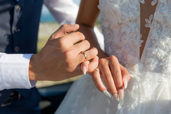 Imagem de homem e mulher com anel de casamento.Casal jovem de mãos dadas, dia do casamento cerimônia. Mãos de casal recém-casados com anéis de casamento — Fotografia de Stock