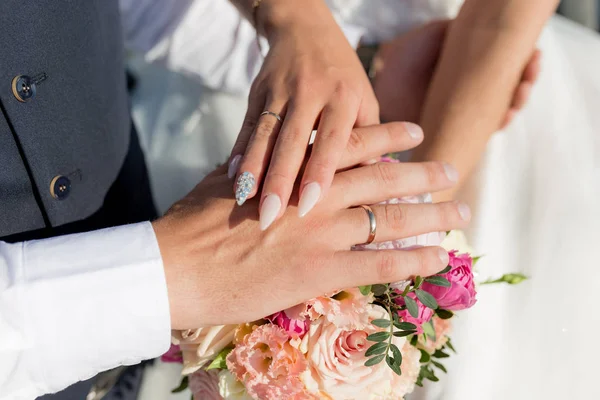 Зображення чоловіка і жінки з обручкою. Молода подружня пара тримає руки, день весілля церемонії. Руки новоспеченої пари з обручками — стокове фото