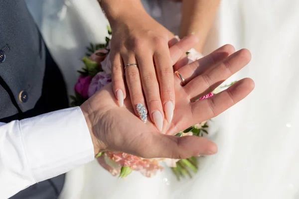 Imagem de homem e mulher com anel de casamento.Casal jovem de mãos dadas, dia do casamento cerimônia. Mãos de casal recém-casados com anéis de casamento — Fotografia de Stock