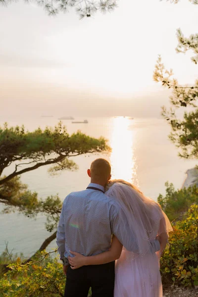 Couple looking at the sea in wedding clothing. Back view — Stock Photo, Image