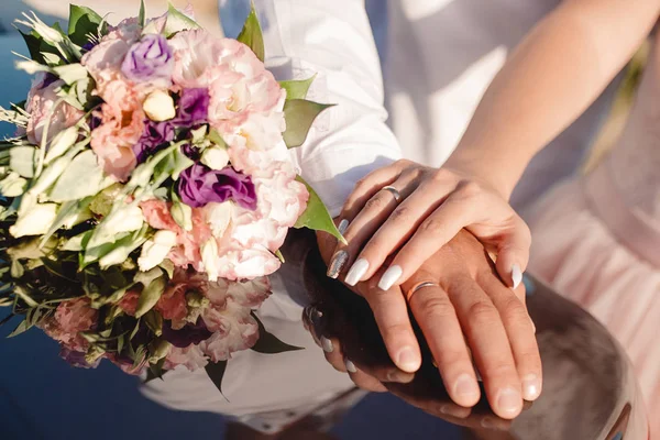 Mãos de noiva e noivo com anéis perto do buquê de casamento. Conceito de casamento — Fotografia de Stock