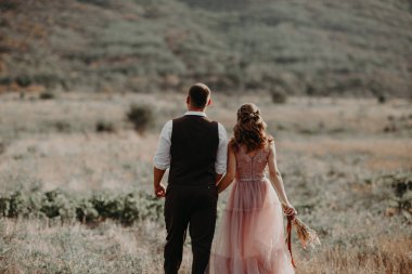 Güzel düğün çift, gelin ve damat, arka planda dağların aşık