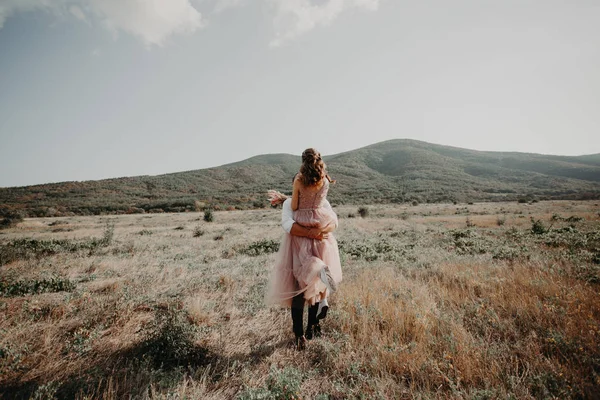 Güzel düğün çift, gelin ve damat, arka planda dağların aşık