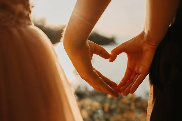 Closeup of couple making heart shape with hands — Stock Photo, Image