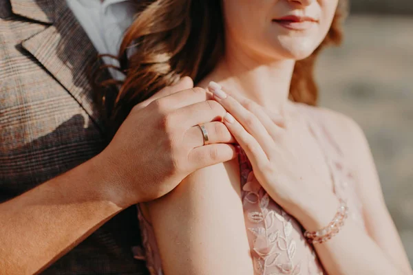 Mãos da noiva e noivo com anéis de casamento abraço, detalhe do casamento — Fotografia de Stock