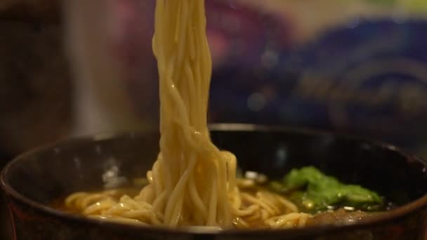 慢动作的人在亚洲餐馆吃饭时吃一碗牛肉面 在中国 人们用木棍来吃传统的热食品 — 图库视频影像