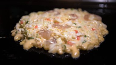 Okonomiyaki Japon yemekleri. Pişirme Monjayaki Japonya restoranda kızarmış.