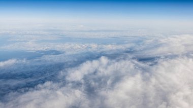 Berrak mavi gökyüzüne sahip güzel bulut manzarası. Uçak penceresinden bir görünüm.