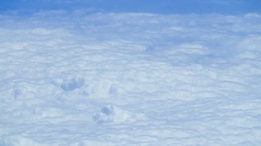 Berrak mavi gökyüzüne sahip güzel bulut manzarası. Uçak penceresinden bir görünüm.