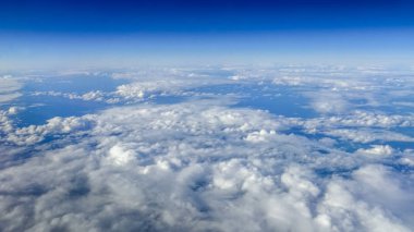 Berrak mavi gökyüzüne sahip güzel bulut manzarası. Uçak penceresinden bir görünüm.