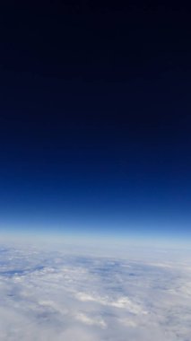 Berrak mavi gökyüzüne sahip güzel bulut manzarası. Uçak penceresinden bir görünüm.