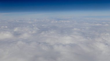 Berrak mavi gökyüzüne sahip güzel bulut manzarası. Uçak penceresinden bir görünüm.