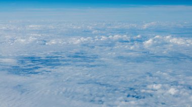 Berrak mavi gökyüzüne sahip güzel bulut manzarası. Uçak penceresinden bir görünüm.