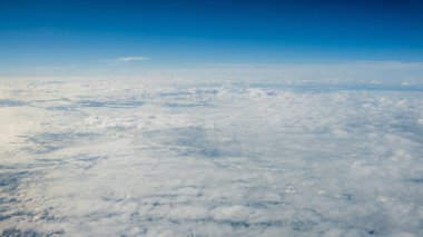 Berrak mavi gökyüzüne sahip güzel bulut manzarası. Uçak penceresinden bir görünüm.