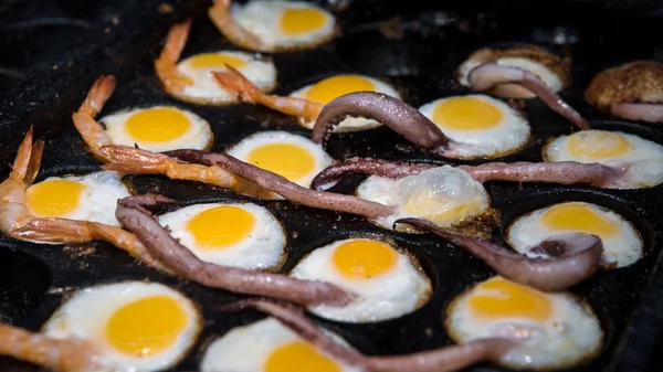 Sprzedawcy uliczni przygotowują smażone jaja przepiórcze z mackami squid i krewetek — Zdjęcie stockowe
