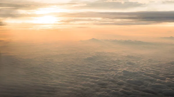 Viaggio aereo. Volare al tramonto o all'alba. Vola attraverso la nuvola arancione e il sole . — Foto Stock