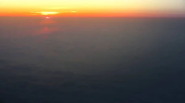 Voyages aériens. Voler au crépuscule ou à l'aube. Voler à travers le nuage orange et le soleil . — Photo