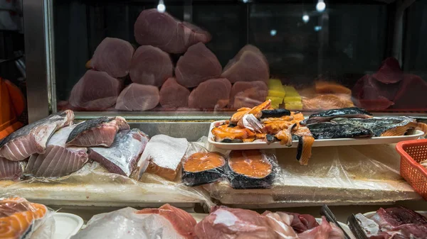 Свежие сырые рыбы на столе в ларьке для продажи. Продажа тунца и лосося — стоковое фото
