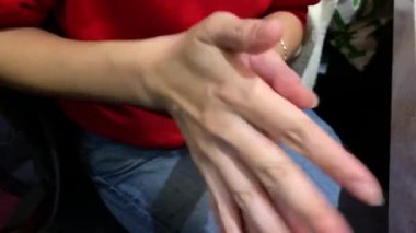 4K, kadın eli bir Asya restoranında şişeden dezenfektan sürüyor. Temiz ellere alkol antiseptik jeli uygulamak ve mikropları önlemek. Coronavirus salgını kavramı.
