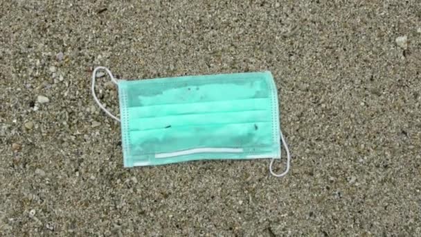 一次性口罩的缓慢运动会在海洋中产生垃圾 废弃的一次性医疗面罩漂浮在海水中 科罗纳威斯废物污染环境 — 图库视频影像