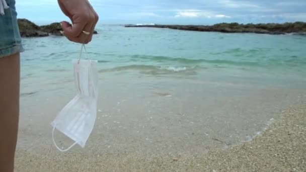 Mano Femenina Sosteniendo Máscara Médica Relajándose Playa Mujer Joven Mirando — Vídeos de Stock