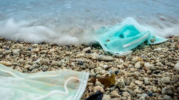 珊瑚类塑料废物污染环境 可处置的面罩会在海洋中喷出垃圾 在海水中弃置的一次性医疗面罩 — 图库照片