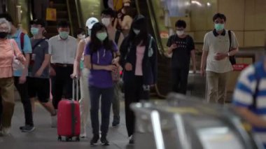 Taipei, Tayvan-04 Haziran 2020: 4K, metro girişindeki yürüyen merdivenlerde bulaşıcı hastalıklara karşı koruyucu maske takan Asyalılar tren istasyonuna gidiyor. Coronavirus koruması - Dan