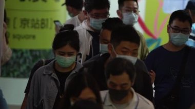 Taipei, Tayvan-07 Haziran 2020: yavaş çekim Tayvanlı erkekler ve kadınlar yüz maskesi takarlar. Metro istasyonunun yürüyen merdivenlerinde maske takan insanlar.