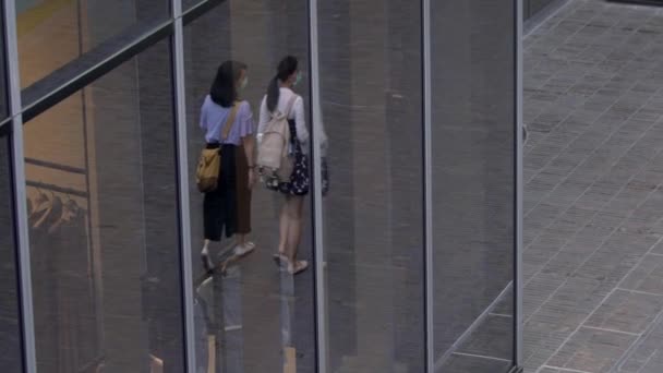 台北2020年5月31日 世界的なコロナウイルス流行中の保護面を身に着けているスローモーションの人々 近代的な建物のガラスを反射して通りを歩くアジアの歩行者 — ストック動画