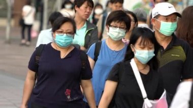 Taipei, Tayvan-04 Haziran 2020: Çin konseptinde koronavirüs salgınının yavaş ilerleyişi. 2019-NCoV numaralı koronavirüs maskesi takan insanlar. Tıbbi maskeli Asyalı bir yaya, Dan Caddesi 'nden geçiyor.