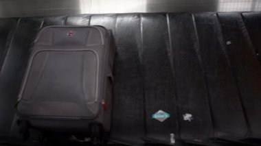4k, havaalanı uluslararası terminal binasının varış salonundaki bagaj teslim yerinde valiz taşıma bandındaki bavul. Bagaj bekleme alanı, yolculuk konsepti - Dan